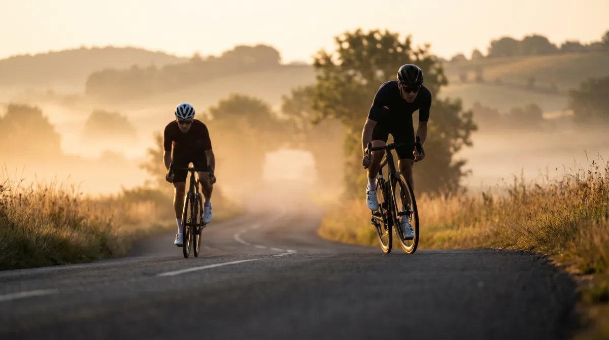 Road cyclist on an empty country road at sunrise in warm golden light